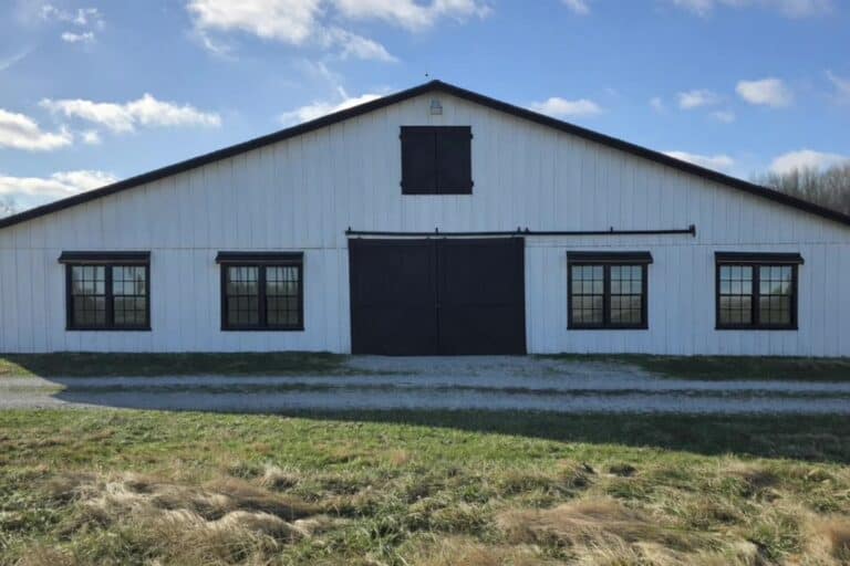 The white barn with black double doors and cupola at Highland Oaks Weddings and Events in Palmyra, Indiana, a barn wedding venue about forty minutes from Louisville