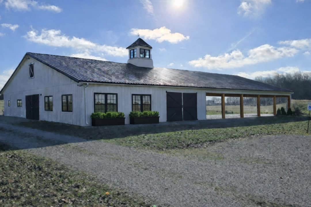 The white barn with cupola and open field at Highland Oaks Weddings and Events in Palmyra, Indiana