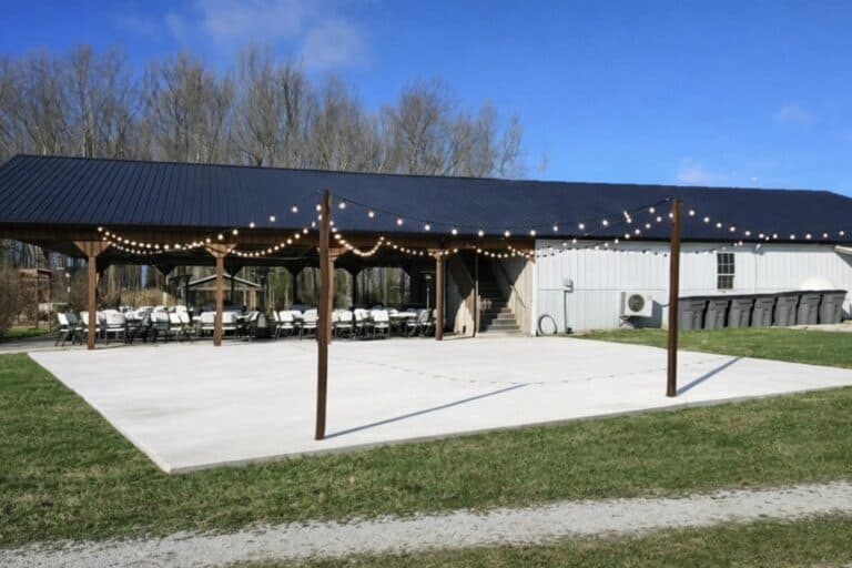 Tables and chairs set under the covered pavilion at Highland Oaks in Palmyra, Indiana, ready for a wedding reception.