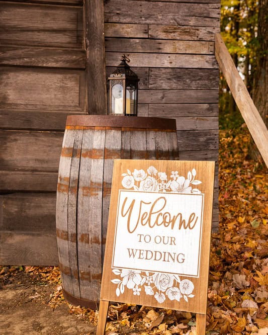Welcome to our wedding sign on a rustic barrel with fall colors at Highland Oaks